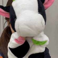 a woman holds a stuffed cow with pink ears
