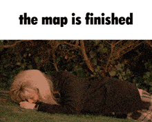 a woman laying on the grass with the words the map is finished below her