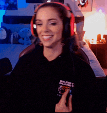 a woman wearing headphones and a shirt that says silent planet is smiling