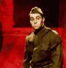a man in a military uniform is dancing in a red room