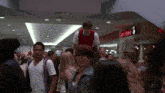 a group of people walking in a mall with a sign that says adobe