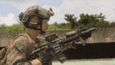 a soldier in a helmet holds a rifle in front of a building with the number 5 on it
