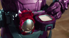 a close up of a purple robot with a red item on its belt