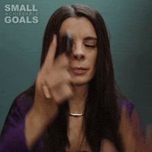 a woman is pointing at the camera with the words small achievable goals on the bottom