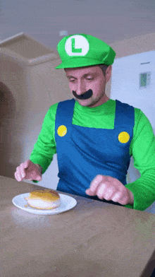 a man dressed as luigi from super mario is eating a donut