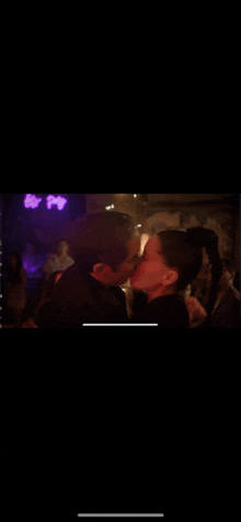 a man and woman kissing in front of a crowd