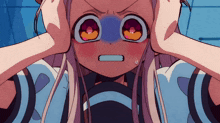 a girl with a blue spot on her nose covering her ears