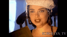 a woman wearing a knitted hat looks at the camera in a video from koroleva tv