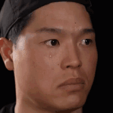 a close up of a man 's face with a tear running down his face .