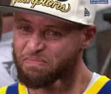 a man with a beard is wearing a hat and making a face .