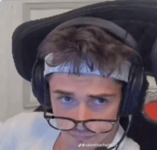a man wearing headphones and glasses is looking at the camera .