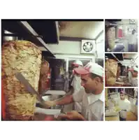 a man in a red hat is cutting a large piece of meat in a kitchen