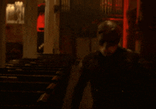 a blurry picture of a man holding a shield in his hand in a dark room .