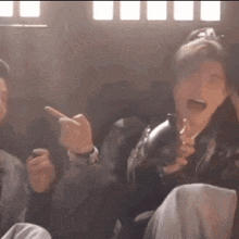a group of people are sitting in a room and laughing .