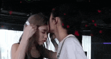 a man and a woman are kissing each other in a dark room .