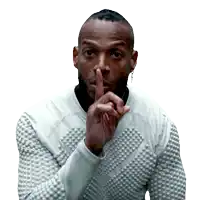 a man in a white sweater is holding his finger to his lips