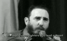 a man with a beard is talking into a microphone with the words that cuban fighters will lend support below him