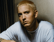 a man with a tattoo on his arm is wearing a white shirt and earrings