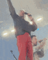 a man and woman singing into microphones on stage