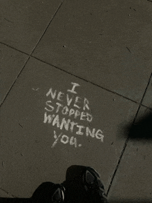 someone has written " i never stopped wanting you " in chalk on the sidewalk