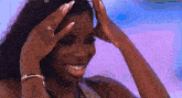 a woman with long nails and a ring on her finger smiles