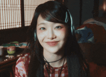 a woman wearing headphones is smiling and winking at the camera