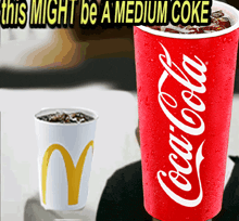 a cup of coca cola sits next to a cup of mcdonald 's