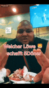 a man with a beard is holding a plate of food and says welcher lowe schafft 5döner