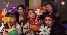 a group of girls are posing for a picture with balloons and a sign that says honeycam.org