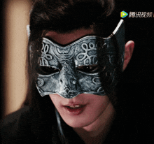 a man wearing a mask with chinese characters on the bottom