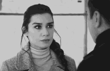 a black and white photo of a man and woman looking at each other