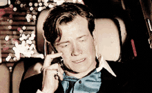 a man talking on a cell phone with his eyes closed