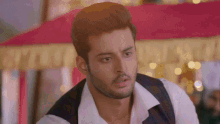 a man with a beard is wearing a white shirt and a vest
