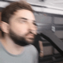 a blurry picture of a man with a beard and a gray shirt