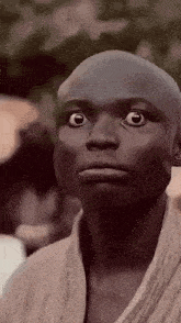 a close up of a person 's face with a bald head .