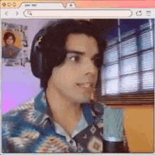 a man wearing headphones and a hawaiian shirt is looking at the camera .