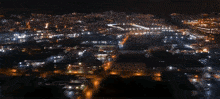 an aerial view of a city at night with a red arrow pointing to a store