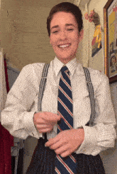 a woman wearing a striped shirt and suspenders smiles