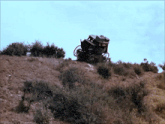 a horse drawn carriage is sitting on top of a dirt hill