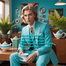 a man in a blue suit is sitting at a table with a cup of tea