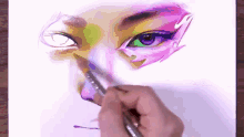 a person is painting a woman 's eye with a brush