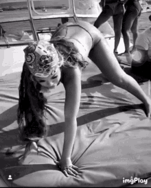 a black and white photo of a woman doing a handstand with imgplay at the bottom right