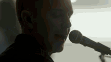 a close up of a man singing into a microphone that says sennheiser