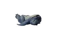 a blue stuffed animal is laying on its back on a white surface