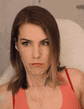 a close up of a woman wearing headphones and a red tank top