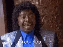 a man in a suit and tie is smiling and saying i got you .