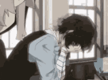 a man is kneeling down with his head in his hands in a room .