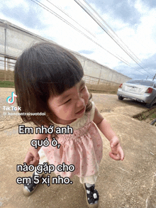 a little girl is standing in front of a car and a sign that says tiktok on it