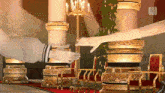 a man and a woman shake hands in a room with gold columns