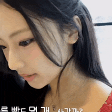 a close up of a woman 's face with korean writing on the bottom right